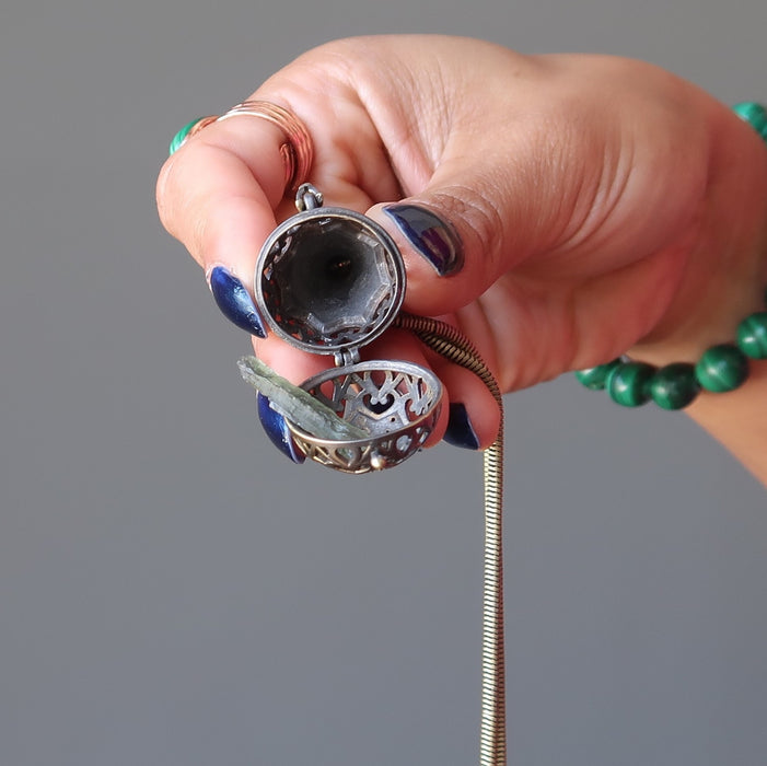 hand holding moldavite locket necklace