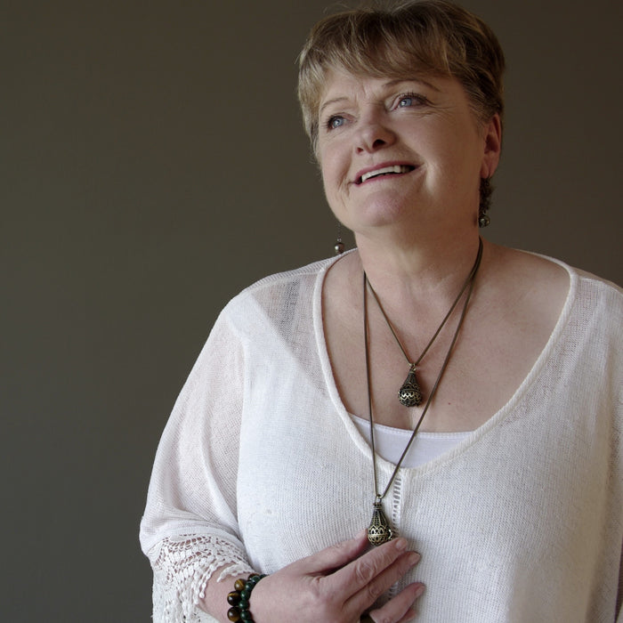 woman at satin crystals modeling moldavite locket necklaces