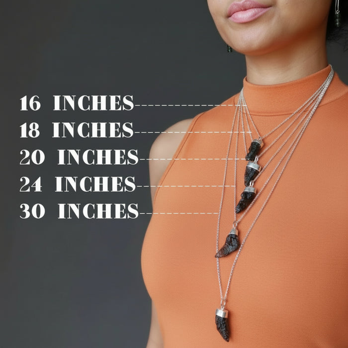 woman moldeling layered moldavite necklaces to show different lengths