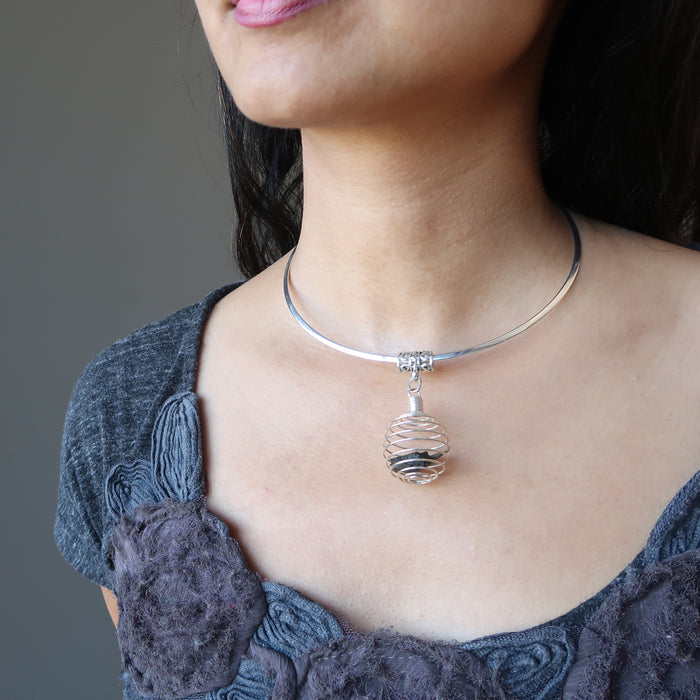 moldavite cage necklace on female