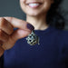 hand holding moldavite pendant at chest