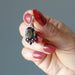 hand holding moldavite garnet pendant