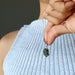 hand holding moldavite garnet pendant