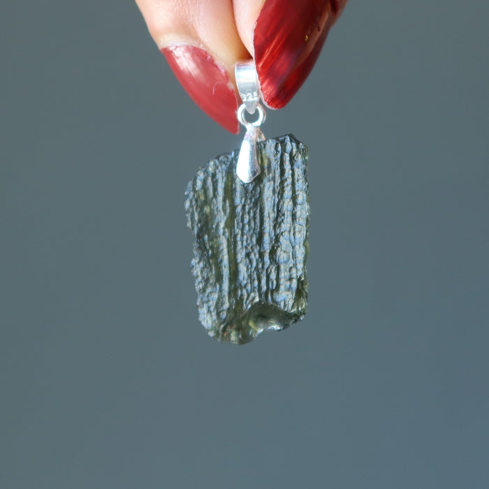 hand holding moldavite pendant