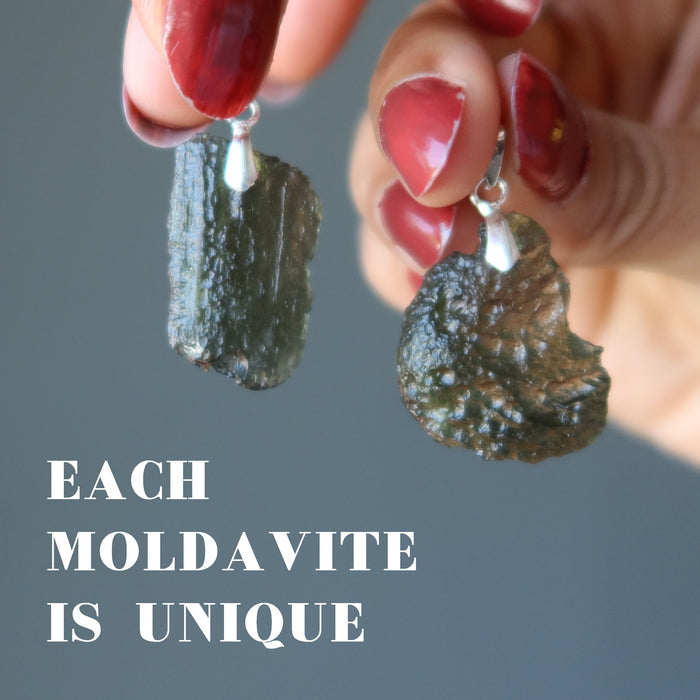 hand holding two moldavite pendants