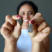 woman holding two moldavite pendant