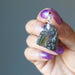 hand holding moldavite pendant