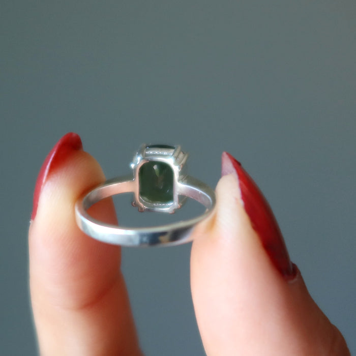 hand holding moldavite ring showing back