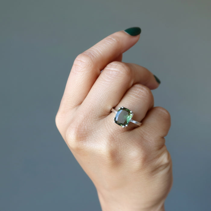 hand wearing moldavite ring on finger
