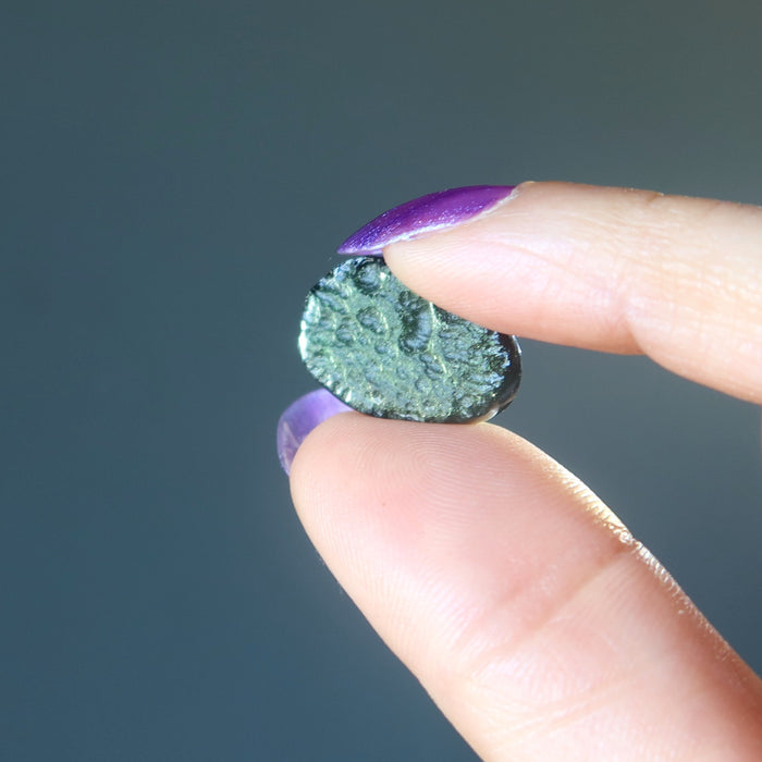 hand holding raw green moldavite