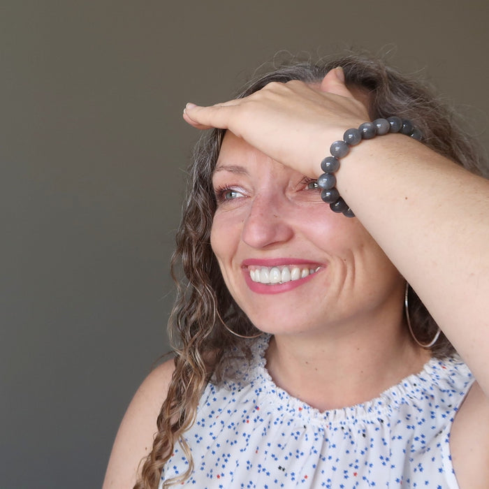 aleks of satin crystals with hand on forehead wearing black moonstone round beaded stretch bracelet