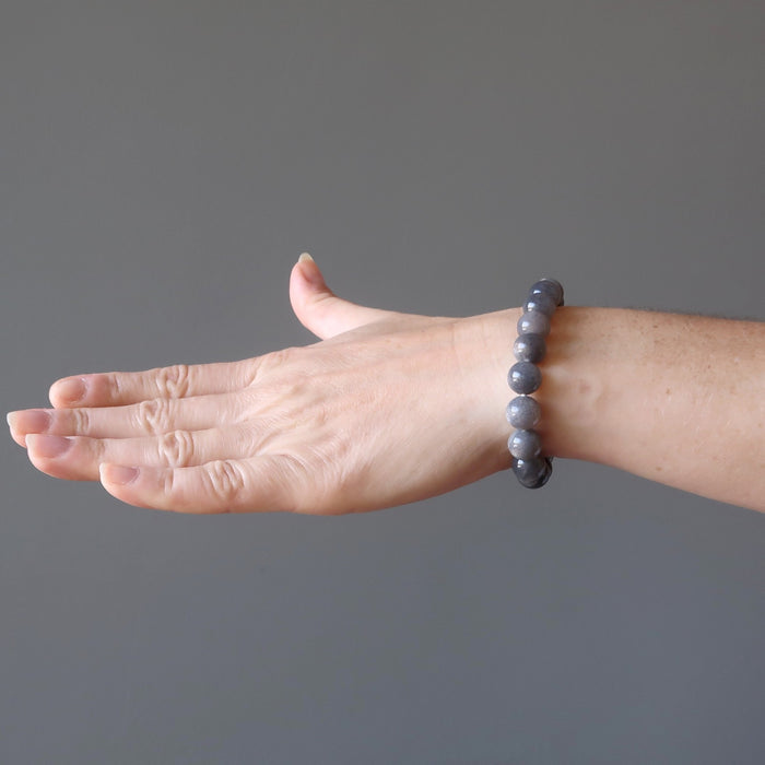 female hand modeling black moonstone round beaded stretch bracelet