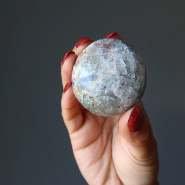 hand holding light black moonstone palm stone