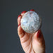 hand holding light black moonstone palm stone
