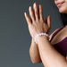 hands in prayer wearing a white moonstone and pink rose quartz round beaded stretch bracelet