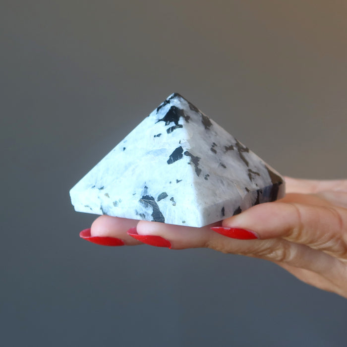 moonstone tourmaline pyramid on palm of hand