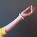 female hand stretched out wearing white rainbow moonstone beaded stretch bracelet