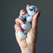 hand holding tumbled moonstone tourmaline stone