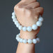 hand holding and wearing white moonstone bracelets