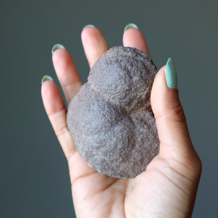 hand holding brown moqui marble cluster