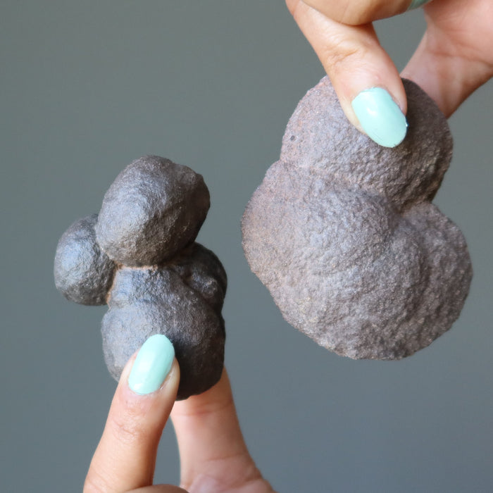 hands holding brown moqui marble clusters