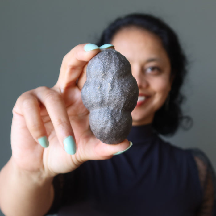 female model holding brown moqui marble cluster