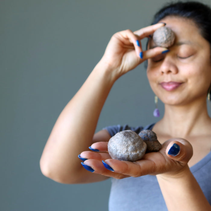 sheila of satin crystals holding two male and one female moqui marble stones in varying sizes