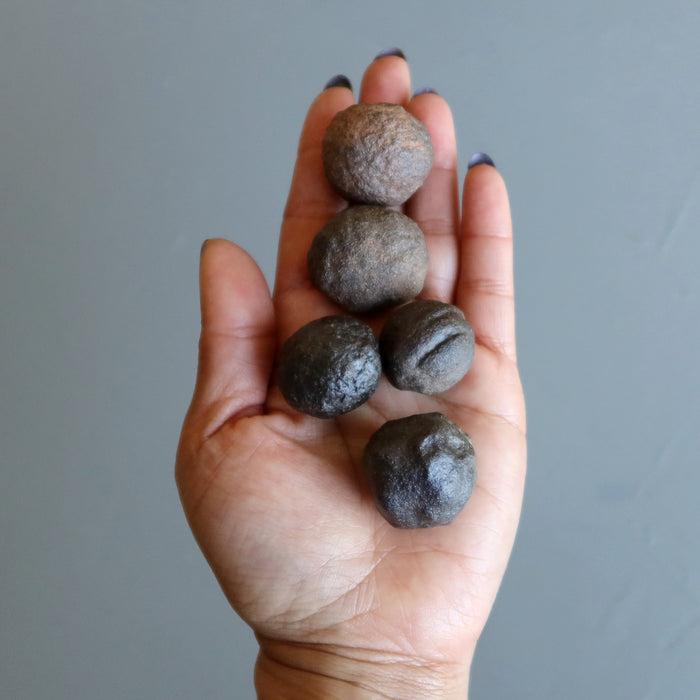 set of 5 brown moqui marble stones in palm of hand