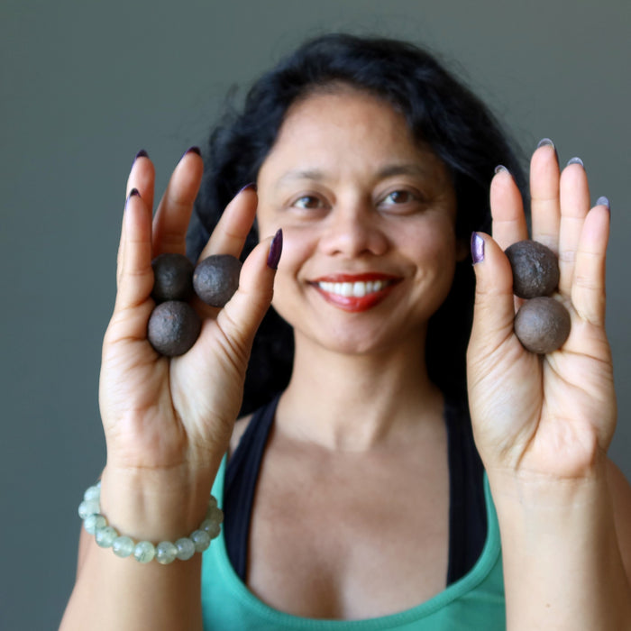 sheila of satin crystals holding hands holding set of 5 brown moqui marble stones 
