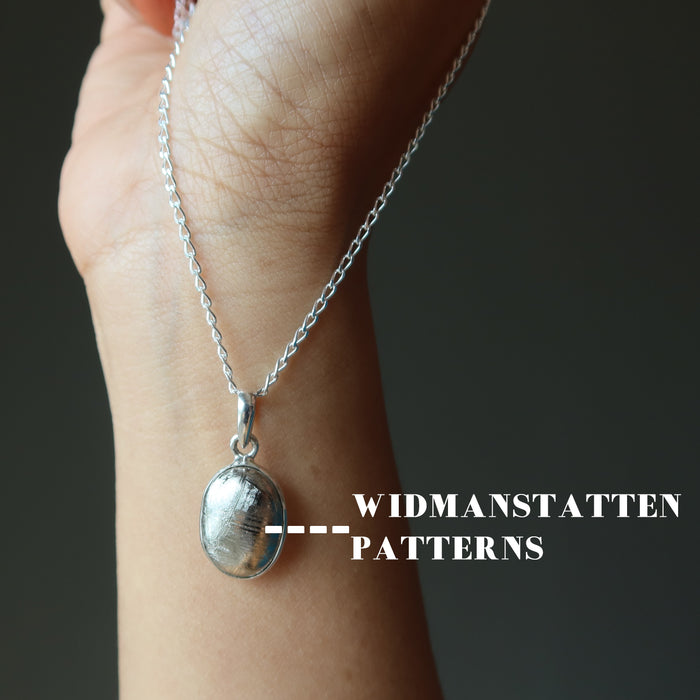 hand holding muonionalusta necklace showing widmanstatten patterns