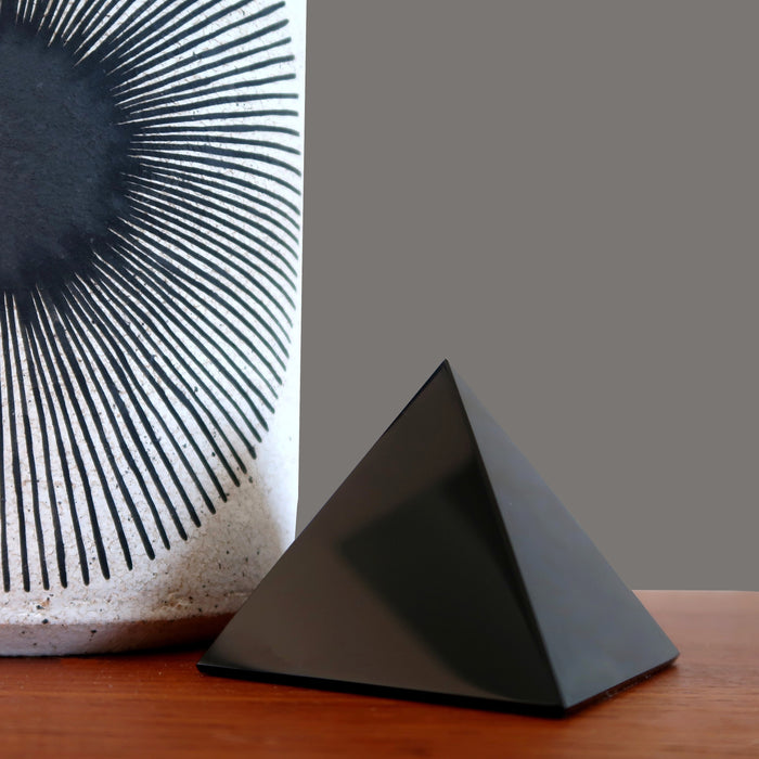 black obsidian pyramid on table