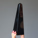hand holding black obsidian obelisk