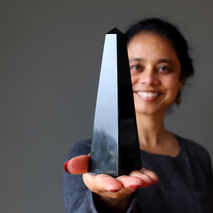 woman holding black obsidian obelisk