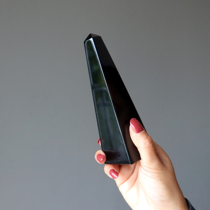 hand holding black obsidian obelisk