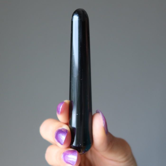 hand holding a black obsidian wand