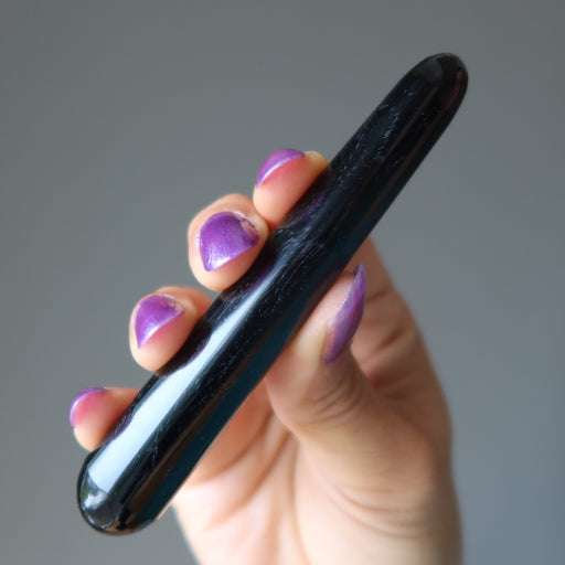 hand holding a black obsidian wand