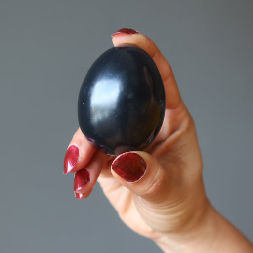 hand holding black obsidian egg