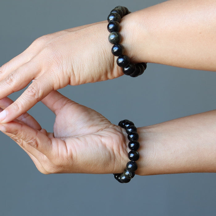 model wearing Gold Sheen Obsidian Bracelets on both wrists