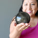 female model holding Gold Sheen Obsidian Sphere