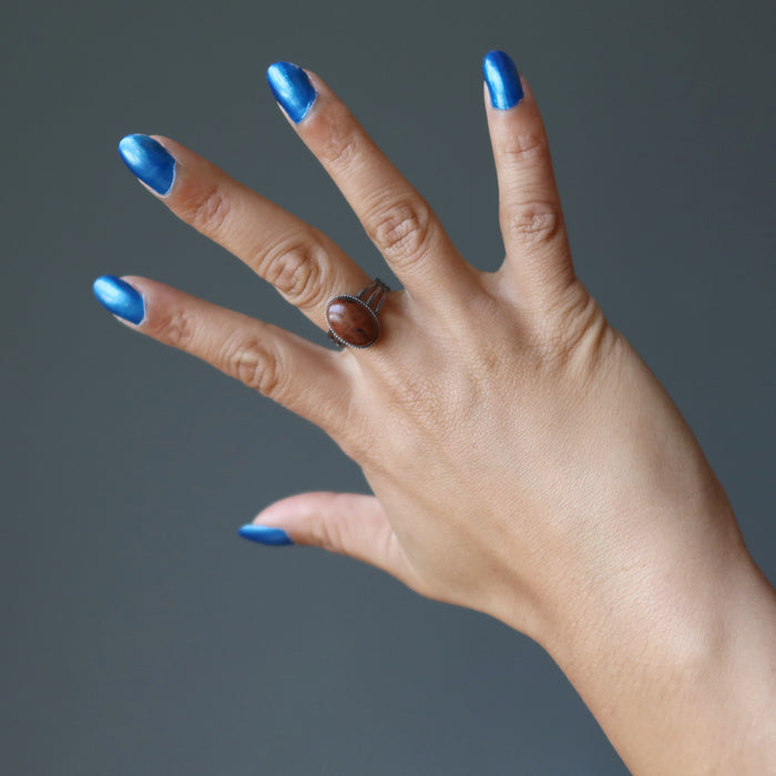 hand wearing mahogany obsidian oval in gunmetal adjustable ring