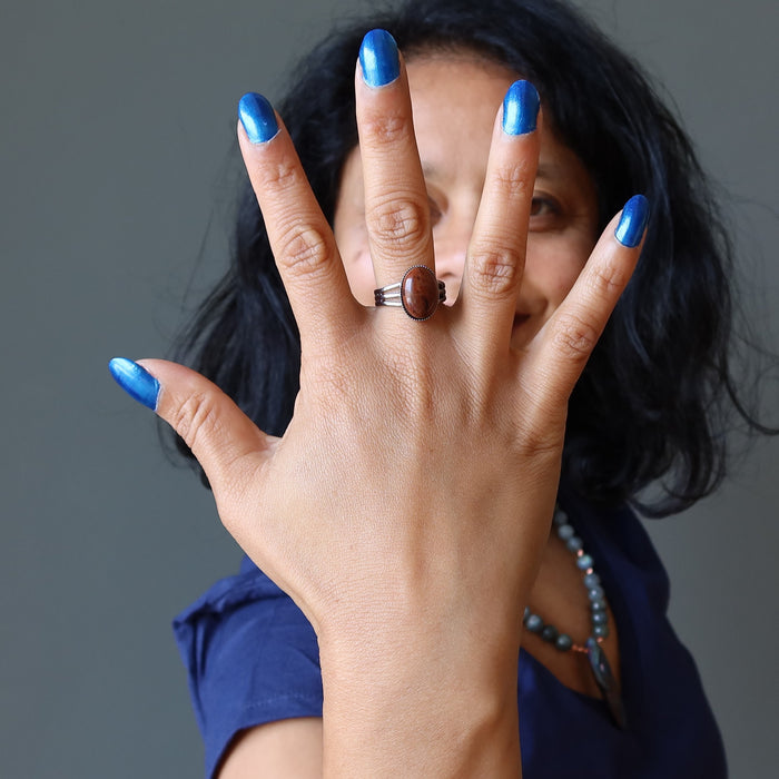 hand wearing mahogany obsidian oval in gunmetal adjustable ring