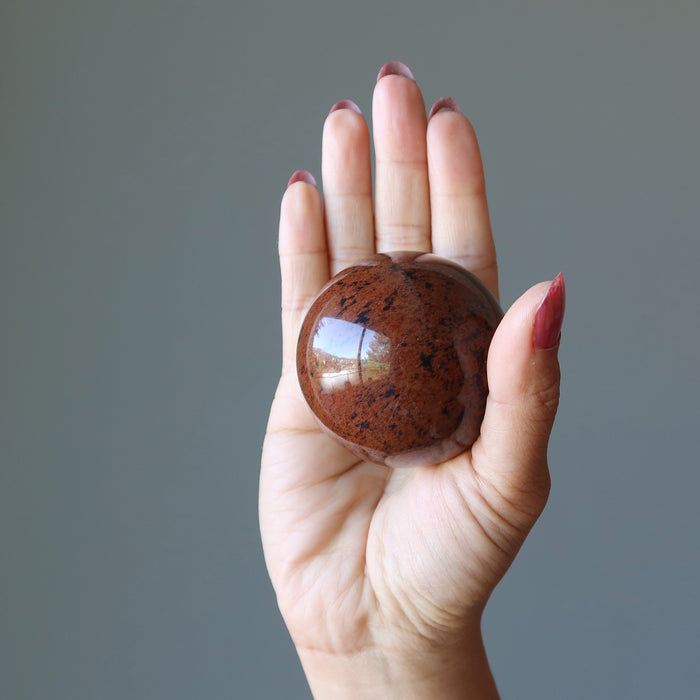 mahogany obsidian sphere in hand