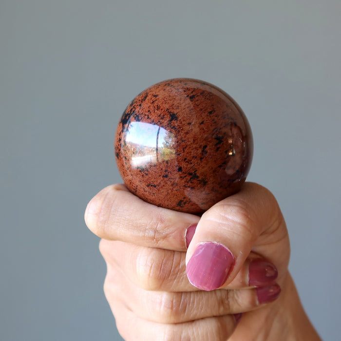mahogany obsidian sphere in hand