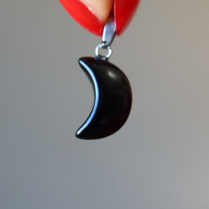 finger tips holding Crescent Moon Black Obsidian Pendant 