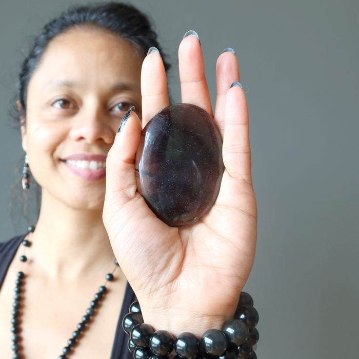 hand holding midnight lace obsidian oval stone