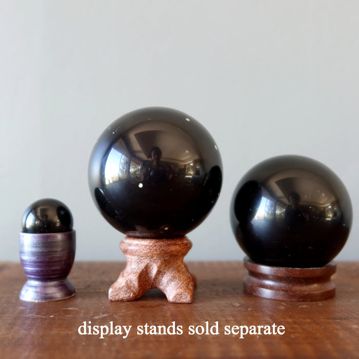 three purple obsidian spheres in stands