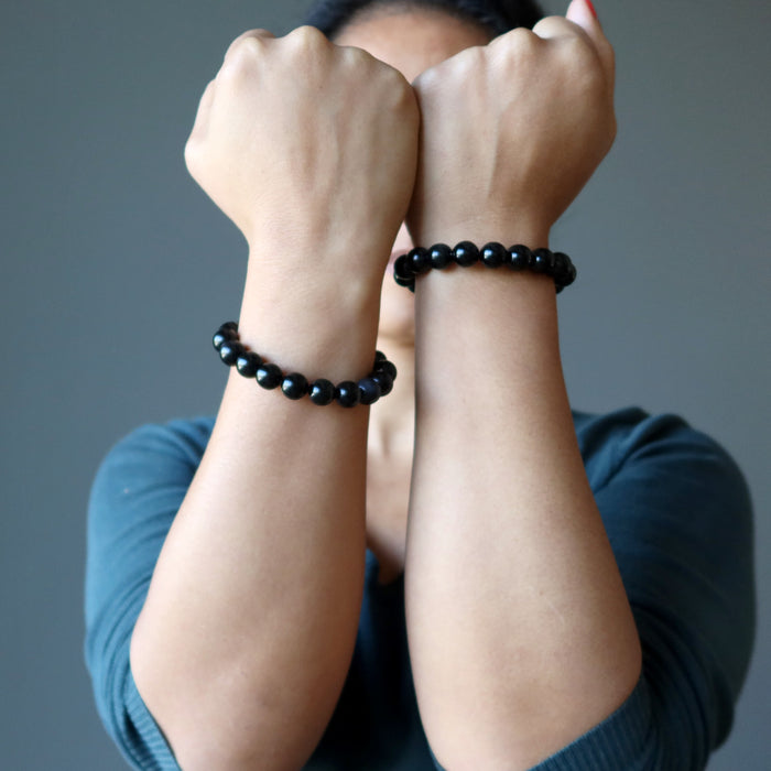 sheila of satin crystals with hands up wearing rainbow obsidian beaded stretch bracelets