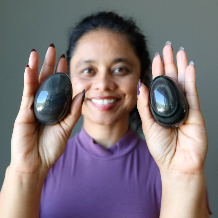 woman holding two obsidian eggs