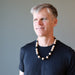 man wearing rainbow obsidian and wood necklace