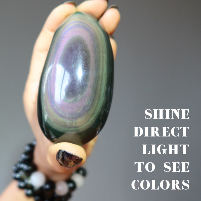 rainbow obsidian palm stone in direct light to see colors